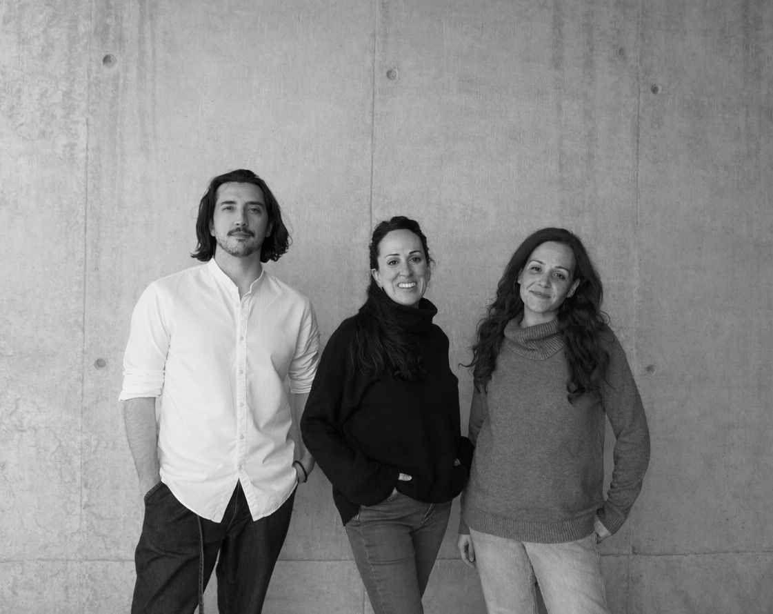 Jaime, Jess y Noelia, fundadorxs de HemeraHub, de pie frente a una pared de hormigón